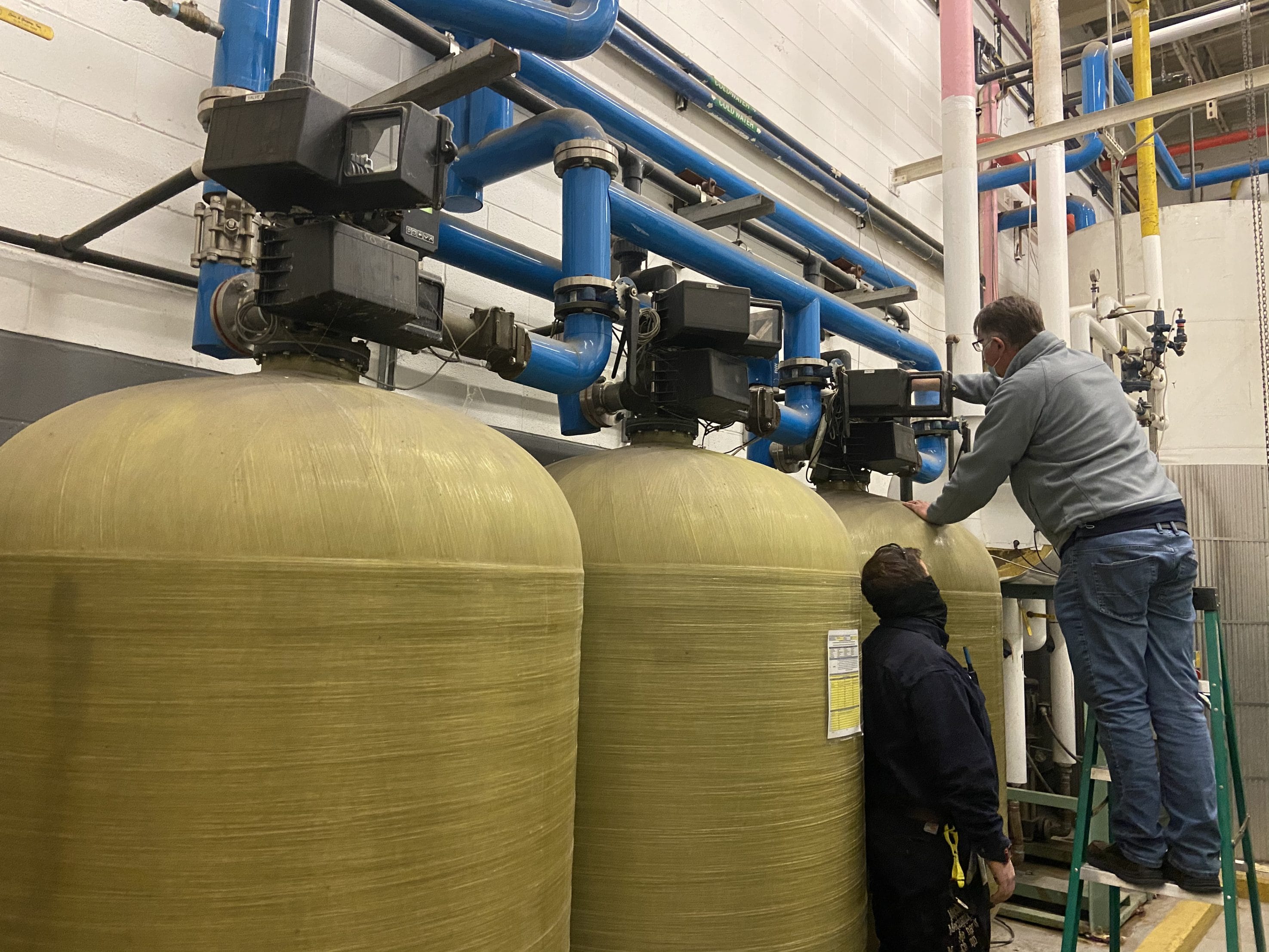 Technicians inspecting commercial water filtration for the warranty under Texas Water House.