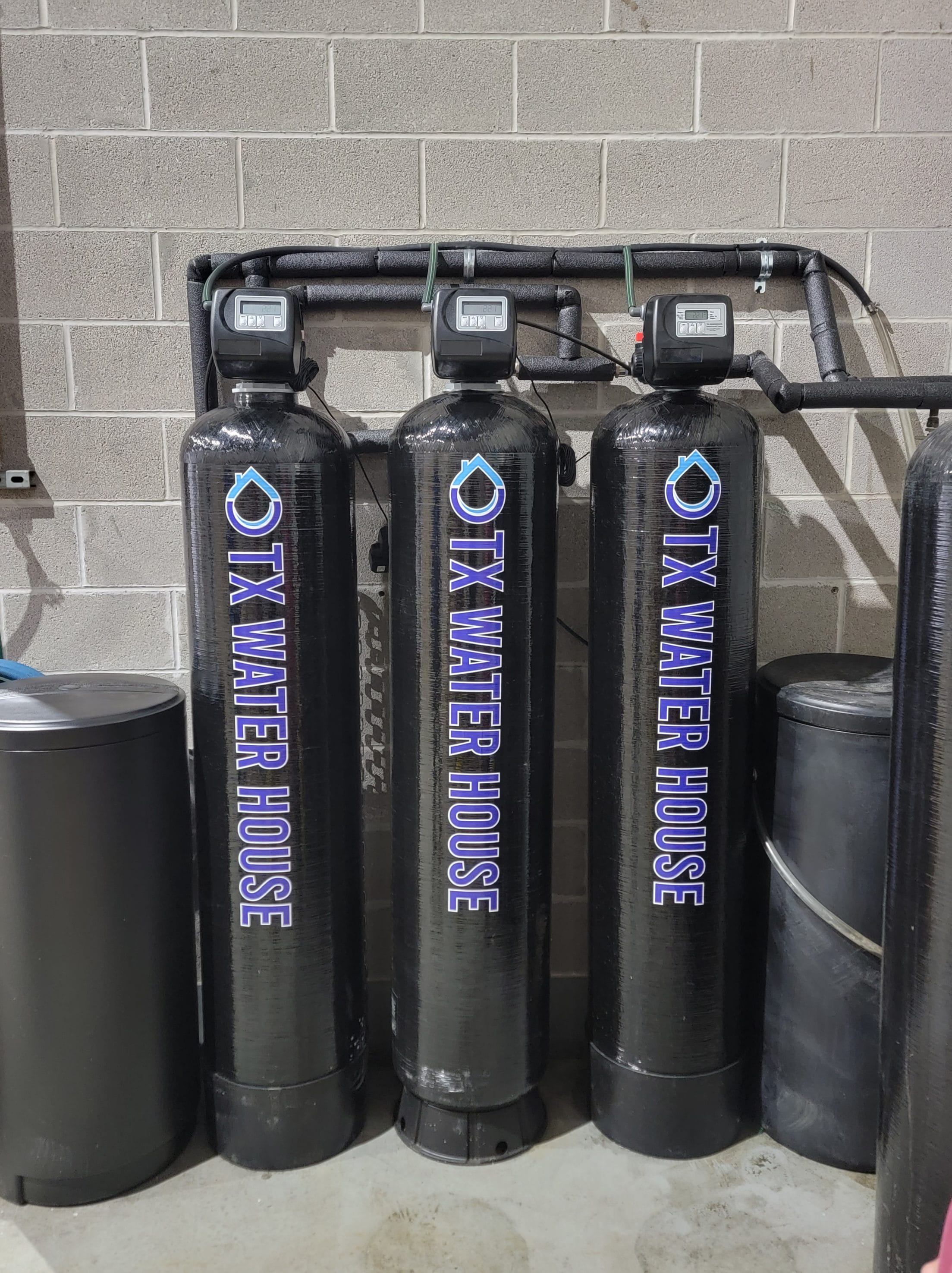 Three black water filtration systems with the Texas Water House logo on them.