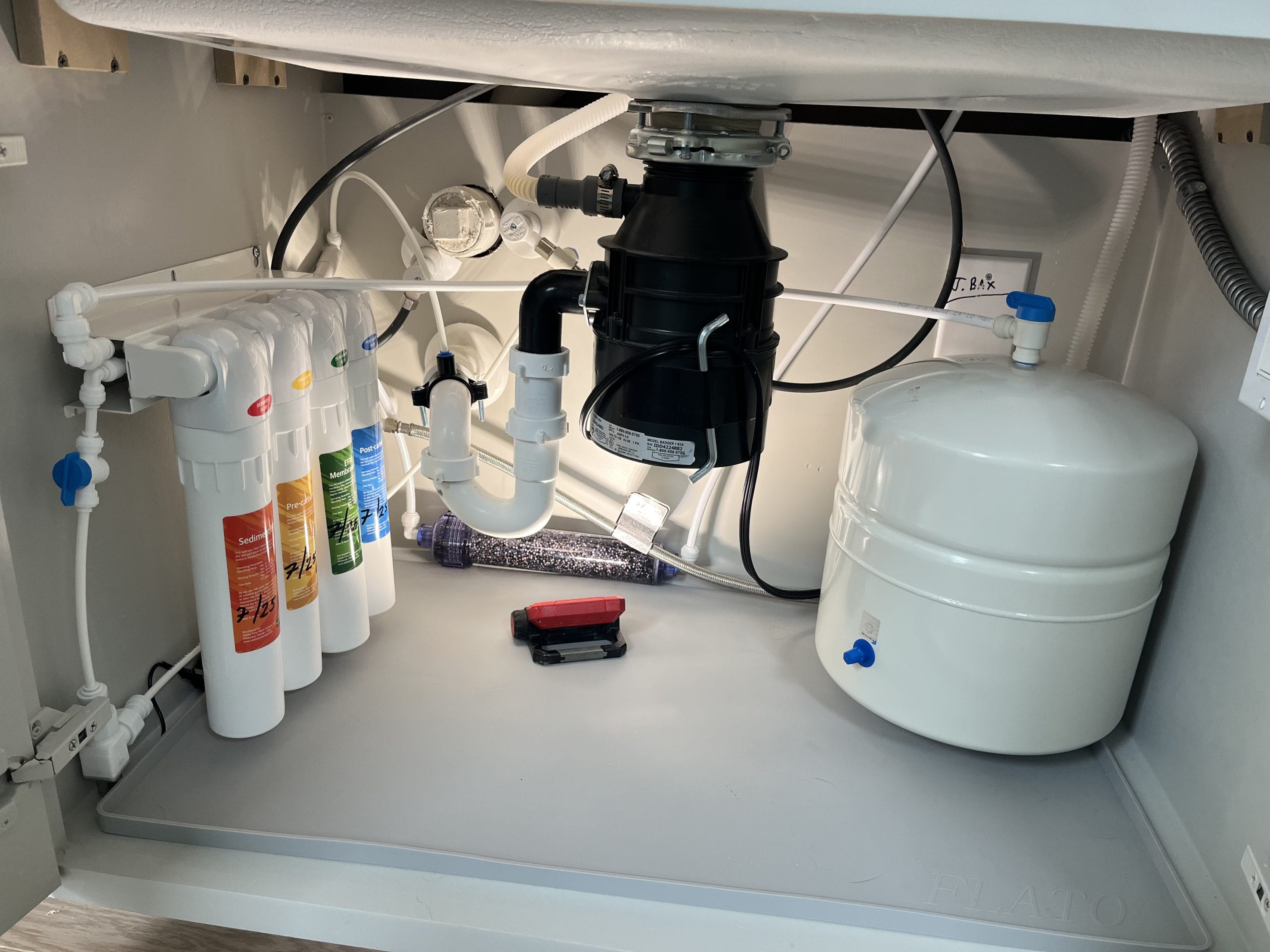 Reverse osmosis system with filters under a kitchen sink.