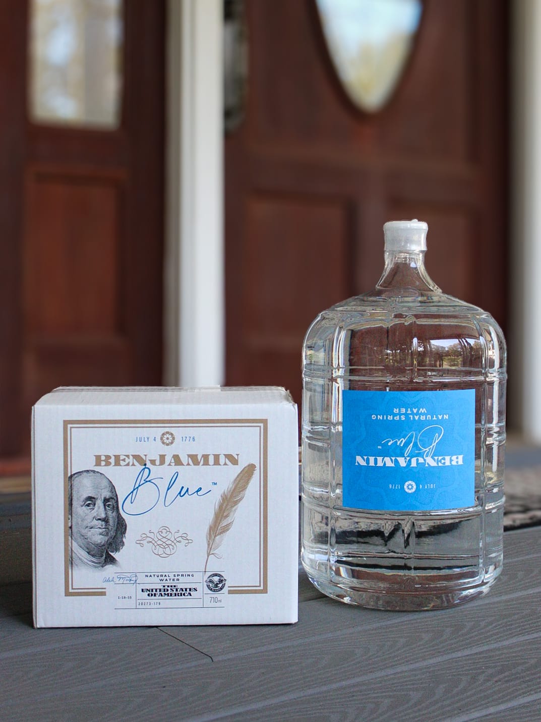 A personalized water jug with crystal clear water in it, next to a box labeled "Benjamin Blue."