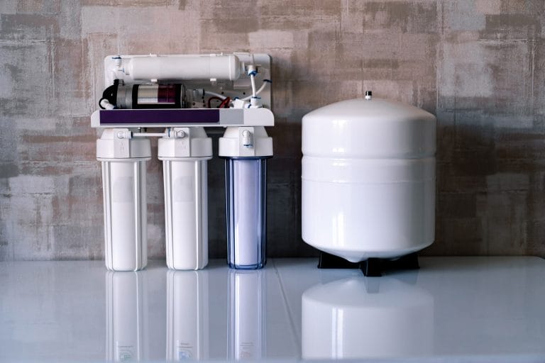 A reverse osmosis system and its filters sitting on a countertop.